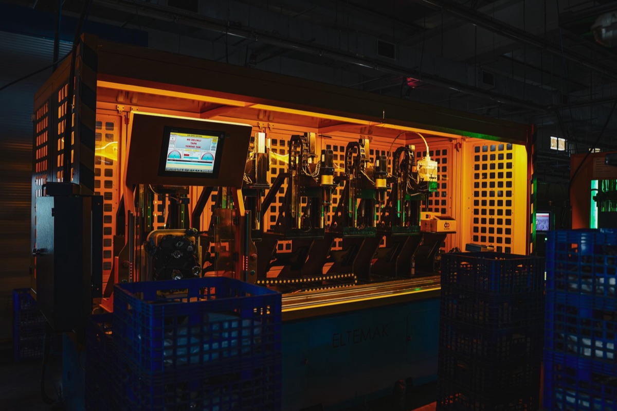 Industrial factory floor with automated machinery and AI monitoring panels
