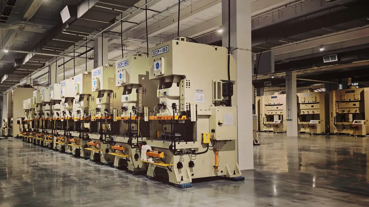A row of industrial machines on a factory floor, highlighting manufacturing equipment.