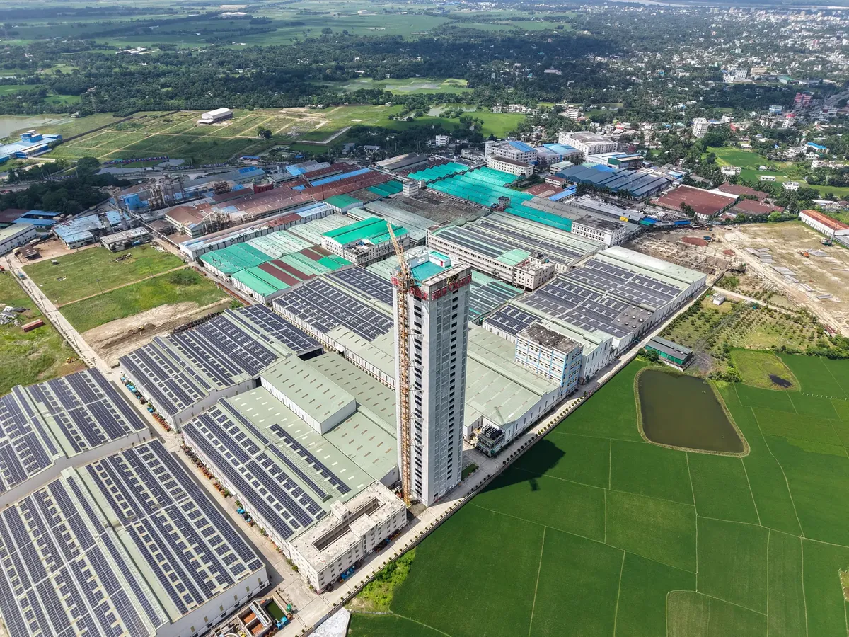 Aerial view of a large industrial factory complex and green fields.